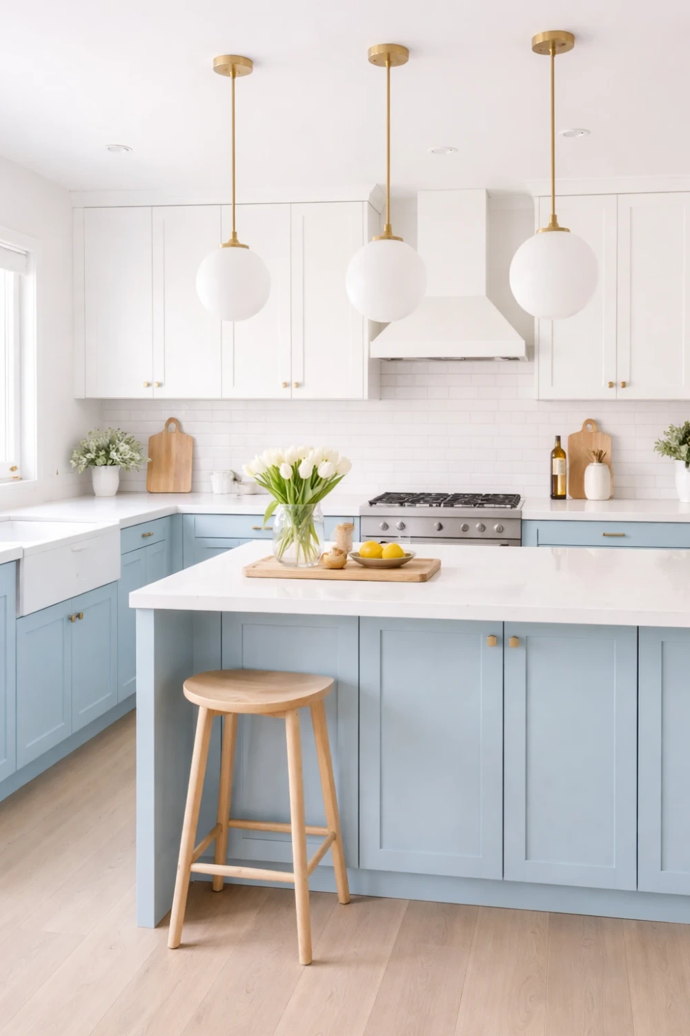 Soft blue and white modern kitchen with large island, gold pendant lights and bright contemporary kitchen decor