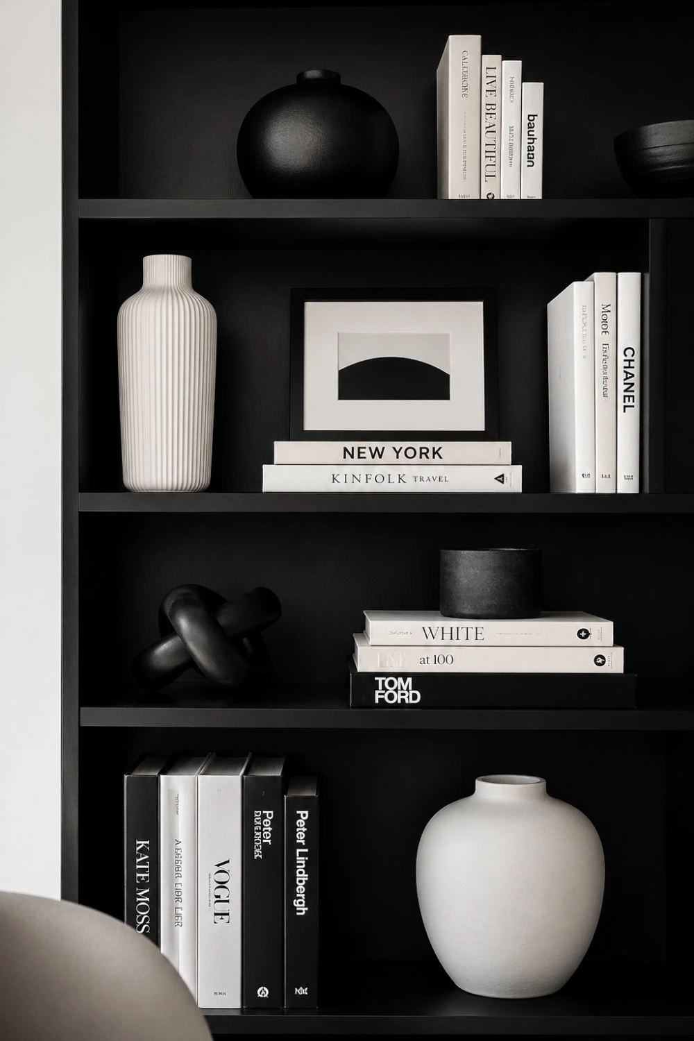 minimalist black and white bookshelf styling with dark shelving, neutral books, ceramic vases, clean lines, modern monochrome shelf decor, luxury minimal interior aesthetic bookshelf setup