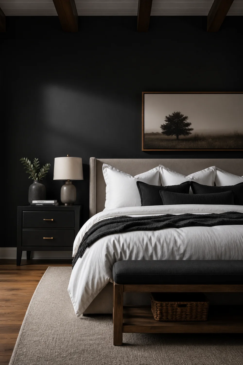 modern farmhouse bedroom with dark charcoal accent wall, black nightstand, white bedding, layered pillows, framed artwork, soft lighting, wood flooring, moody modern interior design