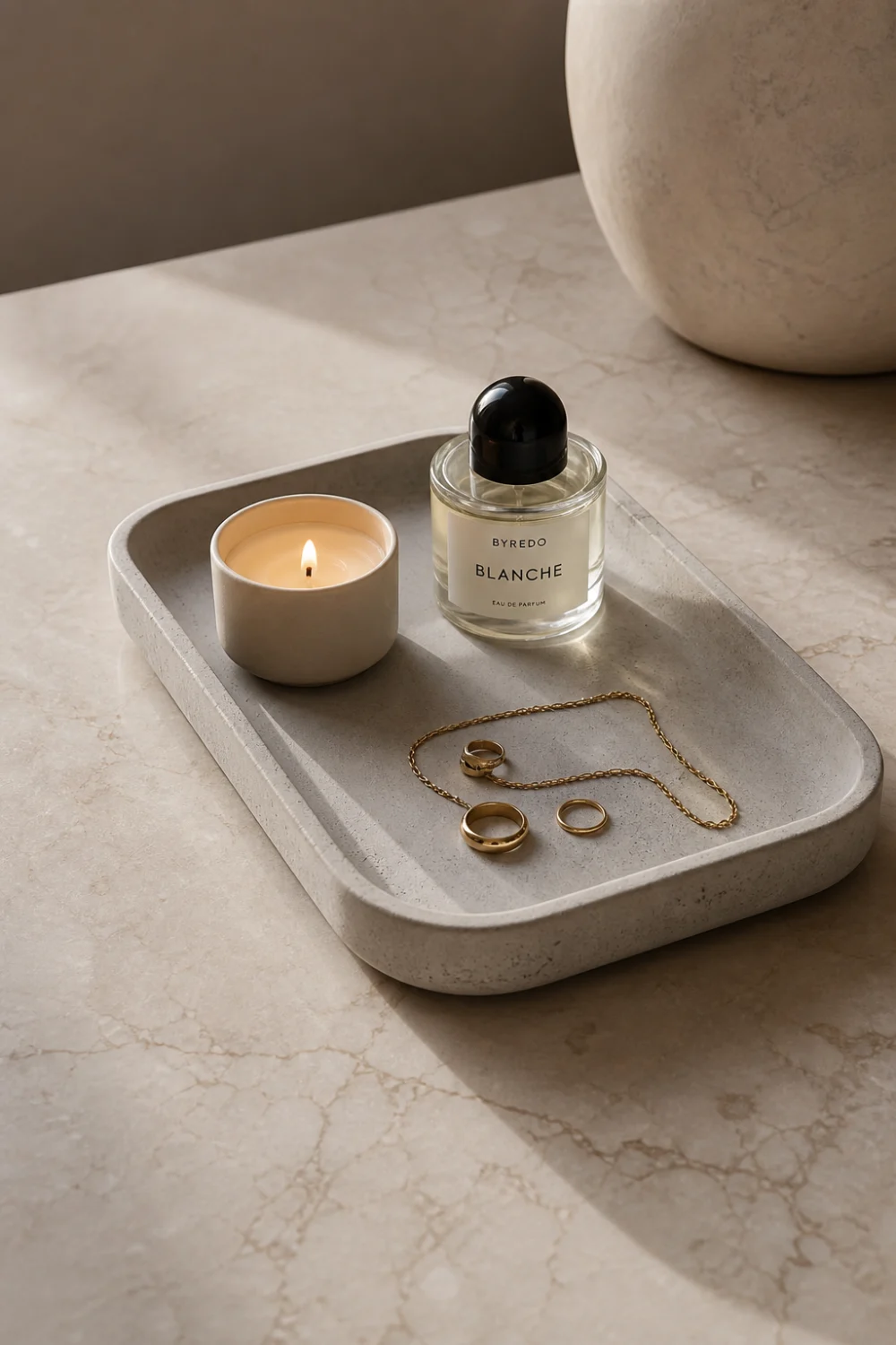 minimalist DIY concrete tray decor styled with candle perfume bottle gold jewelry on marble surface soft natural lighting modern luxury home aesthetic neutral tones high end styling