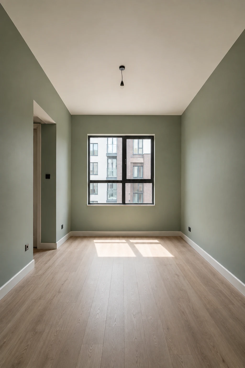 Empty contemporary bedroom with all four walls painted in a soft muted sage green, featuring a clean white ceiling, light oak-style flooring, large rectangular window, simple doorway, crisp white baseboards, realistic matte paint texture, natural daylight, and a calm sophisticated atmosphere highlighting modern sage green bedroom paint.