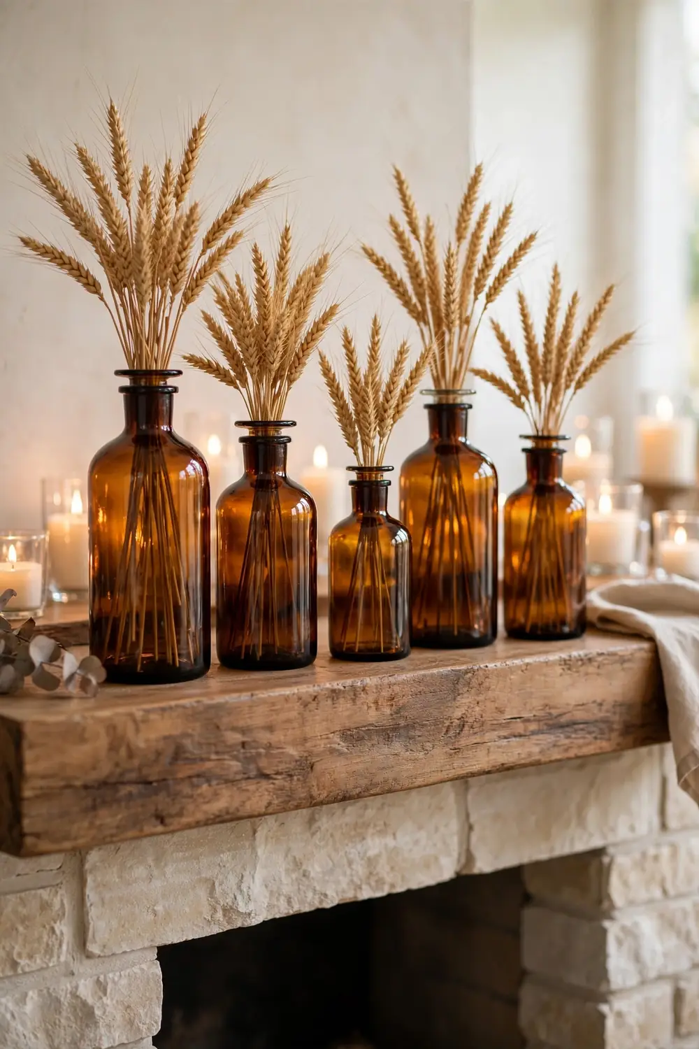 Amber glass bottles on a Thanksgiving mantel Thanksgiving mantel decor ideas with an amber glass bottle collection styled with wheat sprigs