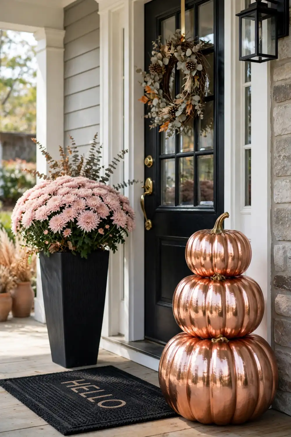 Rose gold pumpkin stack by a front door, glamorous pink halloween decor ideas