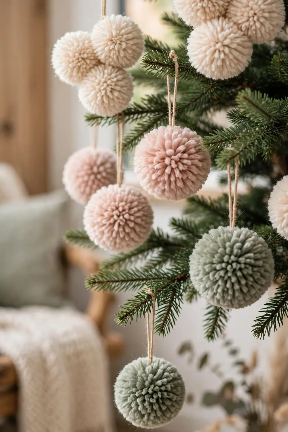 Soft yarn pom pom ornaments in cream and blush, a cozy diy christmas ornament idea