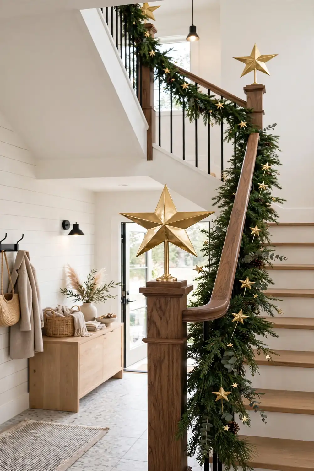 Christmas staircase decor with gold star toppers on newel posts and star picks in green garland